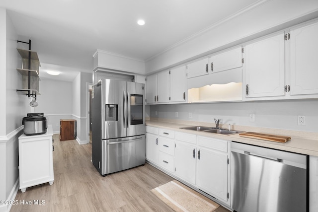 kitchen featuring appliances with stainless steel finishes, a sink, open shelves, white cabinetry, and ornamental molding