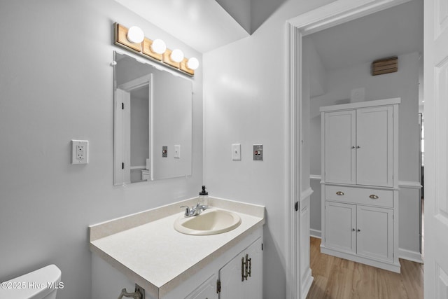 bathroom featuring vanity, toilet, and wood finished floors