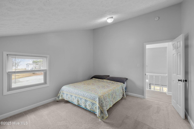 bedroom featuring a textured ceiling, baseboards, vaulted ceiling, and carpet flooring