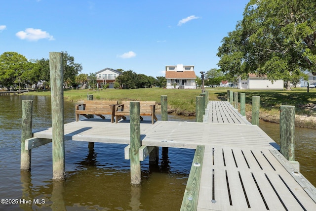 dock area with a lawn and a water view