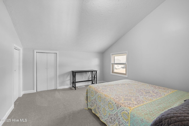 bedroom with lofted ceiling, carpet floors, a textured ceiling, and baseboards