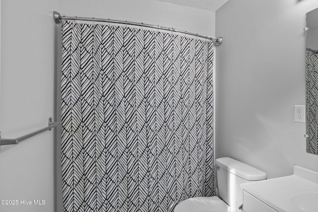 bathroom with toilet, vanity, and curtained shower
