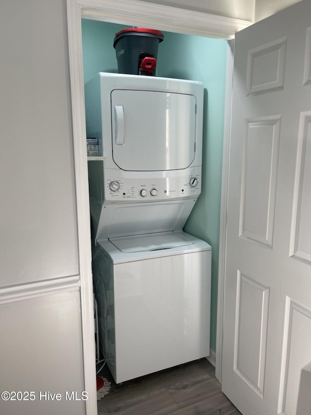 washroom featuring stacked washer and clothes dryer and dark wood-style floors