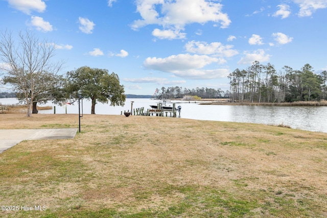 view of dock with a water view, boat lift, and a lawn