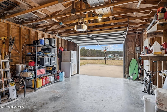 garage with a garage door opener and freestanding refrigerator