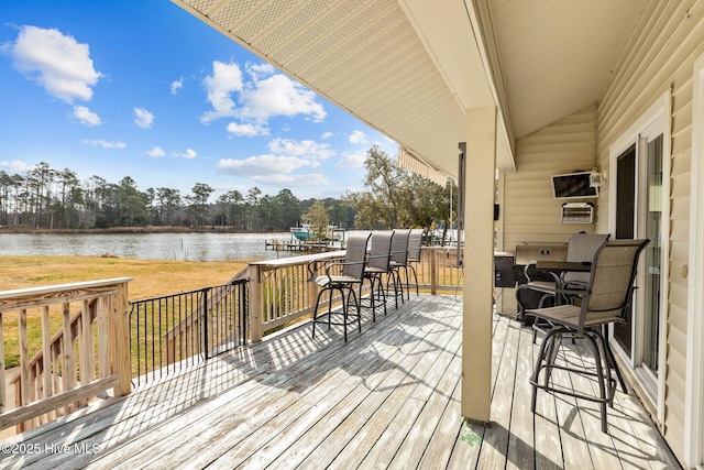 wooden deck featuring a lawn and a water view