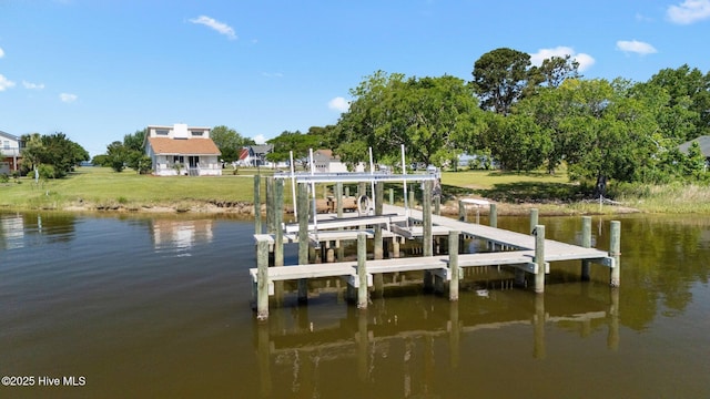 dock area featuring boat lift, a water view, and a yard