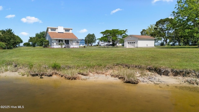 view of green lawn with a detached garage