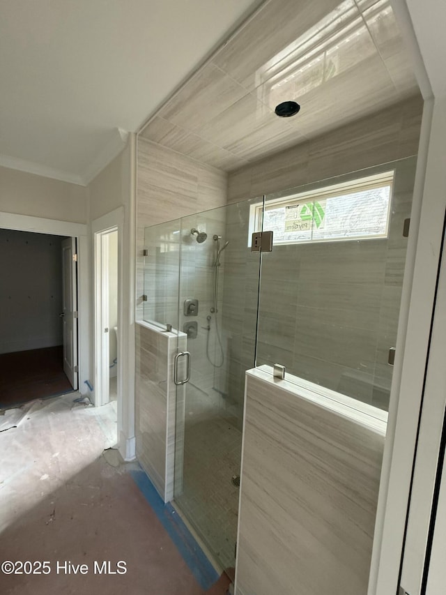 bathroom featuring ornamental molding and an enclosed shower