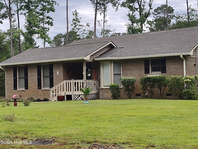 ranch-style house with a front lawn and roof with shingles