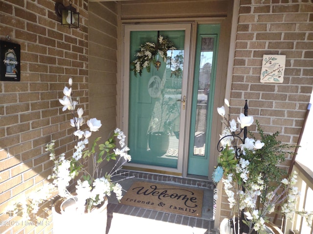 view of exterior entry with brick siding