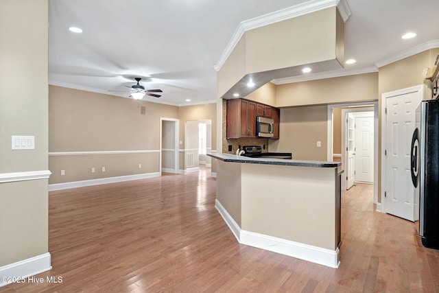 kitchen with ceiling fan, appliances with stainless steel finishes, kitchen peninsula, and light wood-type flooring