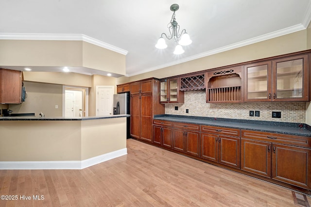 kitchen featuring a notable chandelier, ornamental molding, backsplash, and light hardwood / wood-style floors