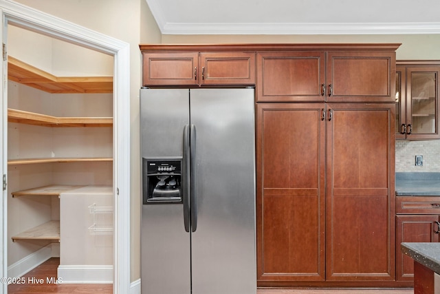 kitchen featuring crown molding, wood-type flooring, and stainless steel fridge