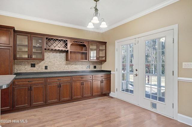 bar with crown molding, an inviting chandelier, hanging light fixtures, light hardwood / wood-style floors, and decorative backsplash