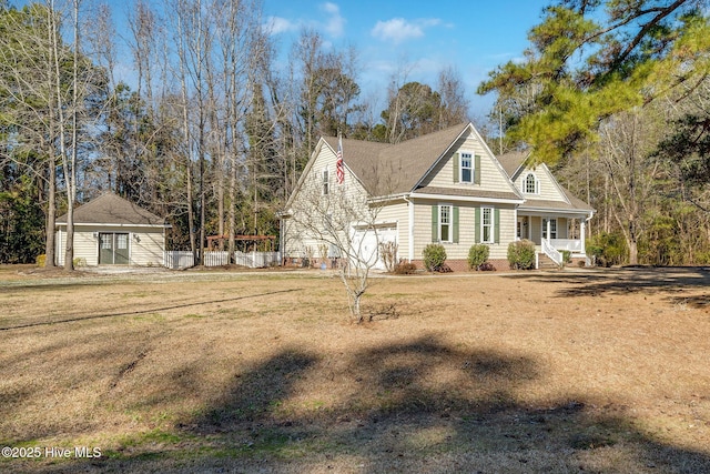 view of front of house featuring a garage, an outbuilding, and a front yard