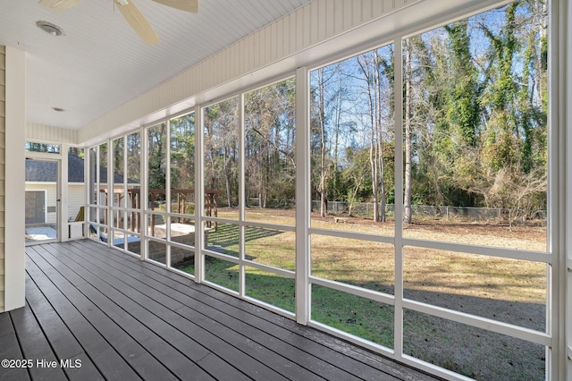 unfurnished sunroom featuring ceiling fan