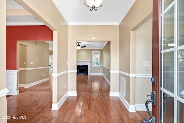 foyer entrance with wood-type flooring, ornamental molding, and ceiling fan