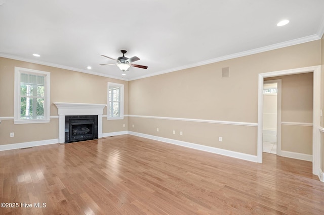 unfurnished living room featuring crown molding, a wealth of natural light, ceiling fan, and light wood-type flooring