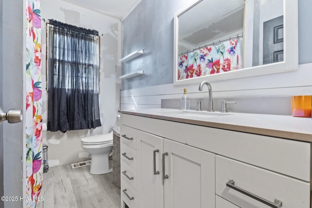 bathroom with vanity, hardwood / wood-style flooring, and toilet