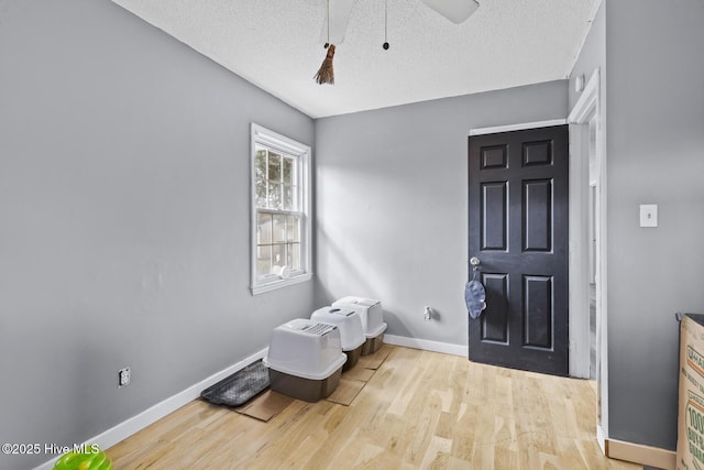 foyer featuring ceiling fan, a textured ceiling, and light wood-type flooring