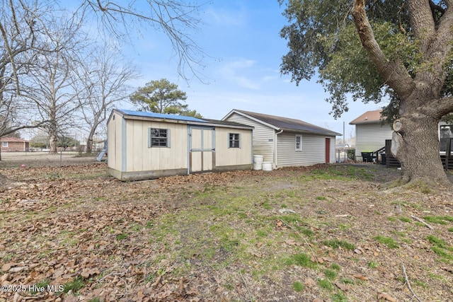 back of house featuring a storage shed