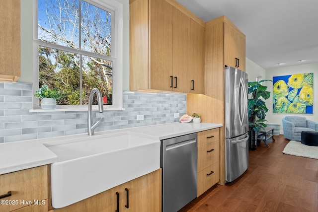 kitchen featuring dark hardwood / wood-style floors, light brown cabinetry, sink, backsplash, and stainless steel appliances