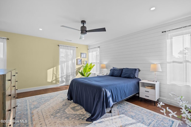 bedroom with dark hardwood / wood-style flooring and ceiling fan