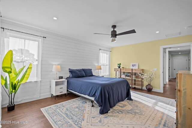 bedroom featuring multiple windows, dark wood-type flooring, and ceiling fan