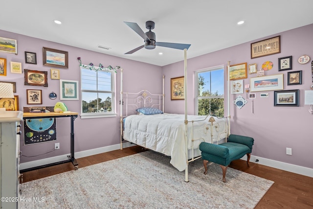 bedroom featuring multiple windows, dark wood-type flooring, and ceiling fan