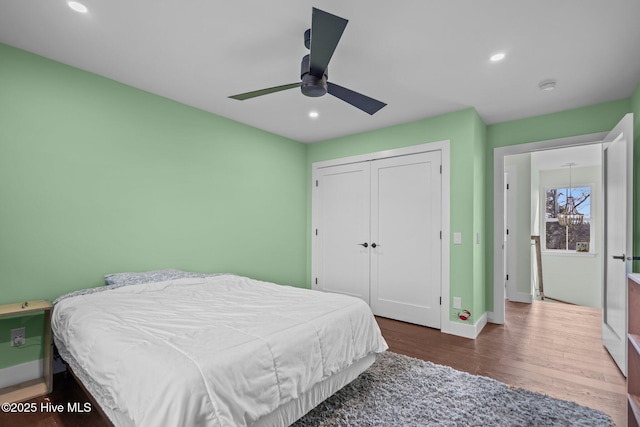 bedroom with dark wood-type flooring, a closet, and ceiling fan