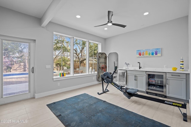 workout room featuring a wealth of natural light, wine cooler, ceiling fan, and indoor wet bar