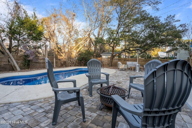 view of patio / terrace with a fenced in pool and an outdoor fire pit