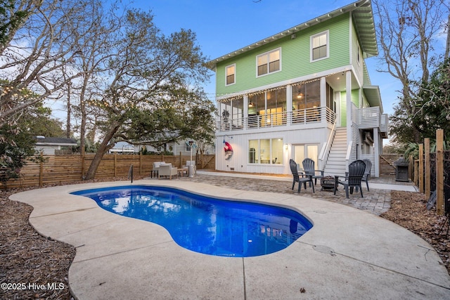 back of house featuring a balcony, a patio area, and a fire pit