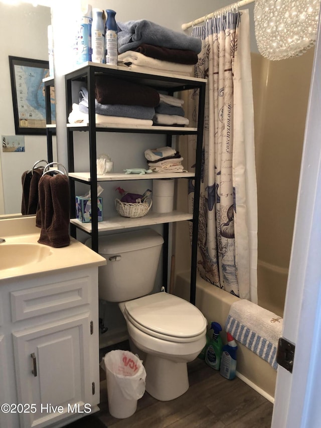 bathroom featuring vanity, shower / tub combo, toilet, and wood finished floors