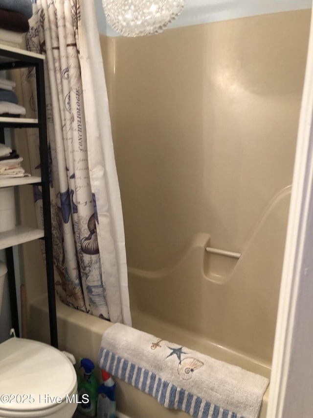 full bathroom featuring shower / tub combo, toilet, and a chandelier