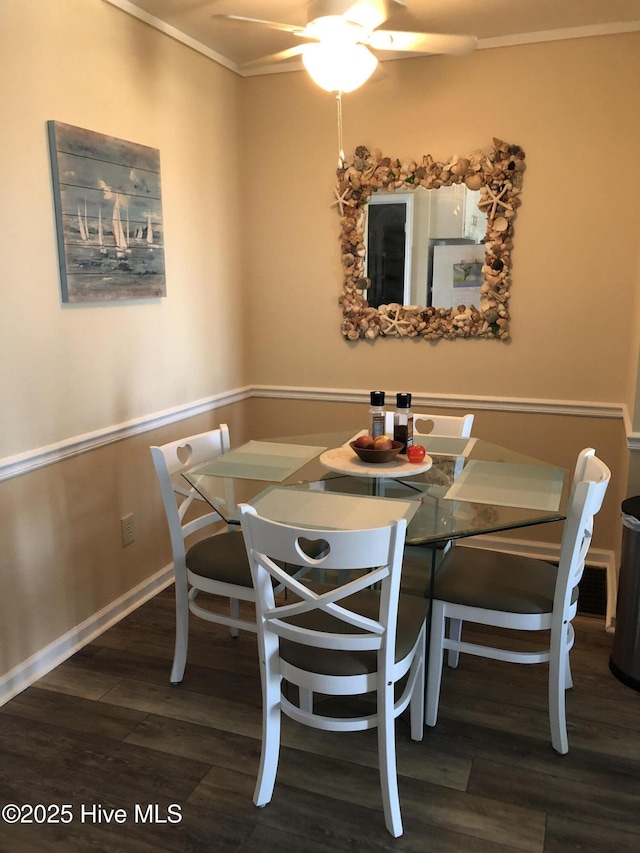 dining room featuring ceiling fan, baseboards, wood finished floors, and ornamental molding