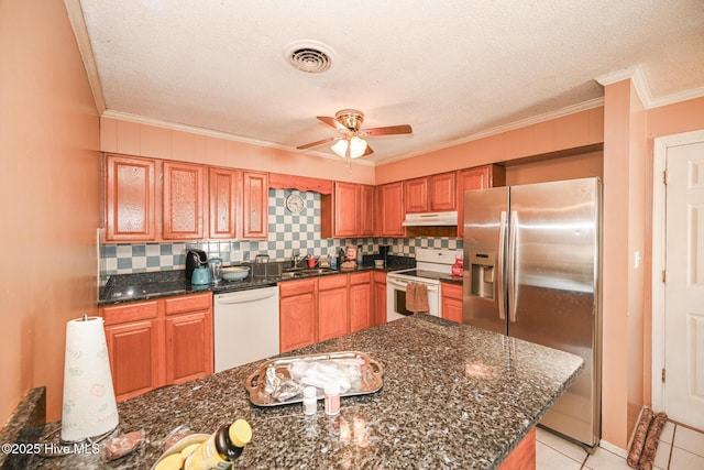 kitchen featuring white appliances, dark stone counters, sink, and backsplash