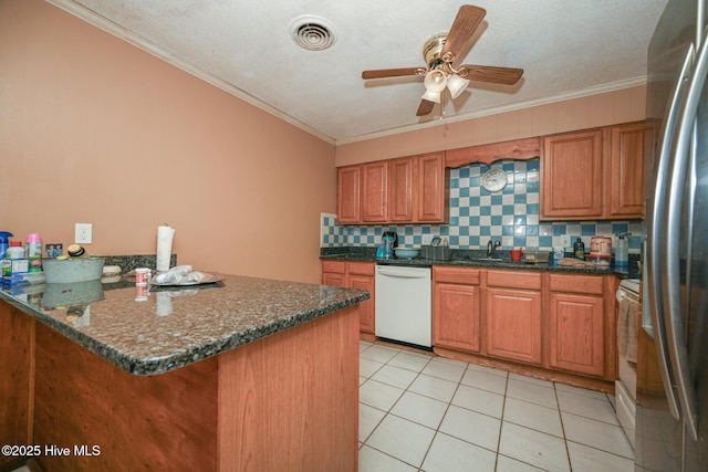 kitchen featuring crown molding, dishwasher, kitchen peninsula, dark stone counters, and decorative backsplash