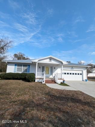 ranch-style home featuring a garage, a front yard, and a porch