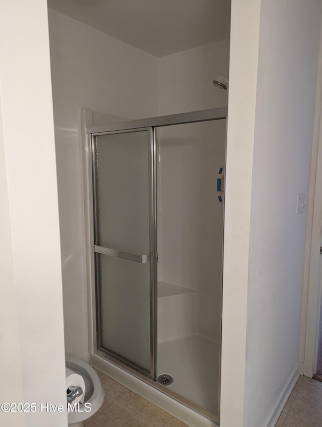 bathroom featuring a shower with shower door and tile patterned flooring