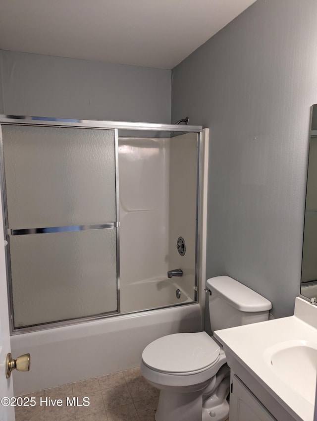 full bathroom featuring tile patterned flooring, vanity, shower / bath combination with glass door, and toilet