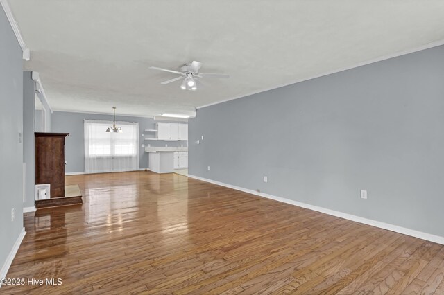 empty room featuring ornamental molding, dark wood-type flooring, and ceiling fan