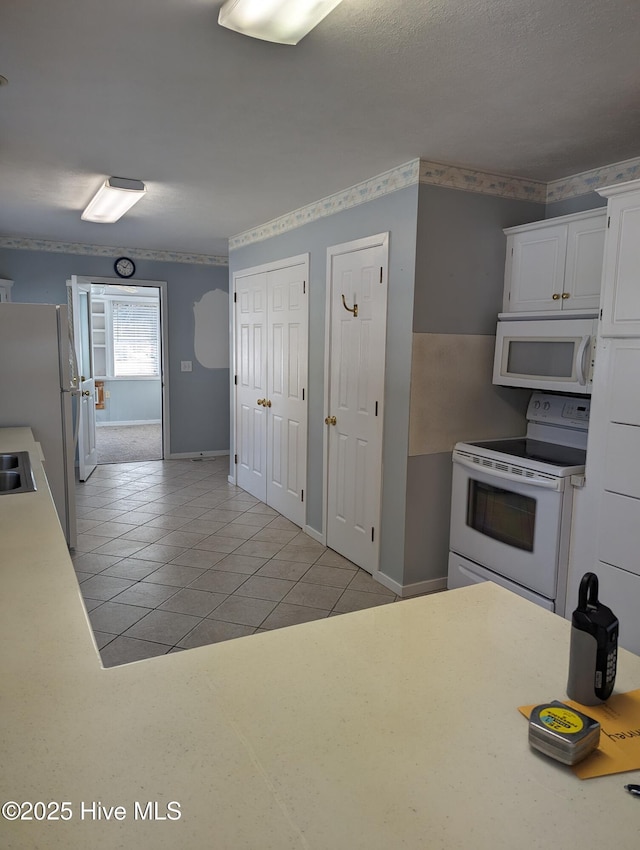 kitchen featuring white cabinetry, white appliances, and light tile patterned floors