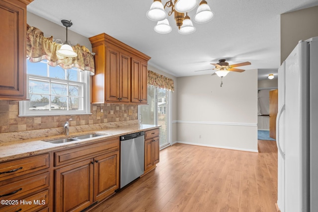 kitchen featuring sink, decorative backsplash, decorative light fixtures, stainless steel dishwasher, and white fridge