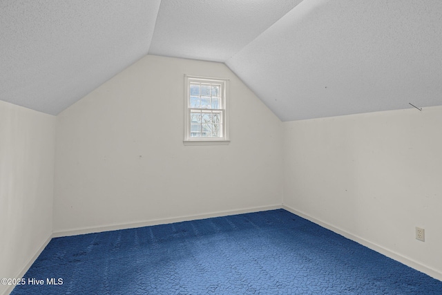 bonus room with carpet flooring, vaulted ceiling, and a textured ceiling