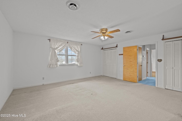 carpeted empty room with a textured ceiling and ceiling fan