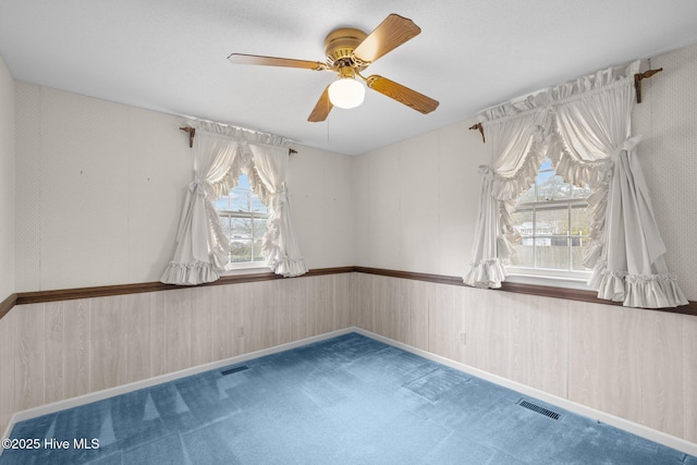 carpeted spare room with ceiling fan and a healthy amount of sunlight