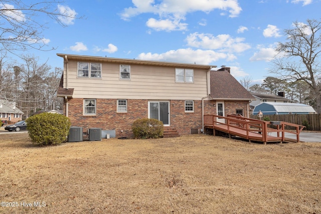 rear view of property with cooling unit, a yard, and a deck