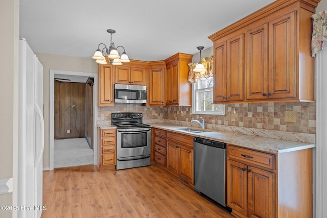 kitchen with pendant lighting, stainless steel appliances, sink, and tasteful backsplash